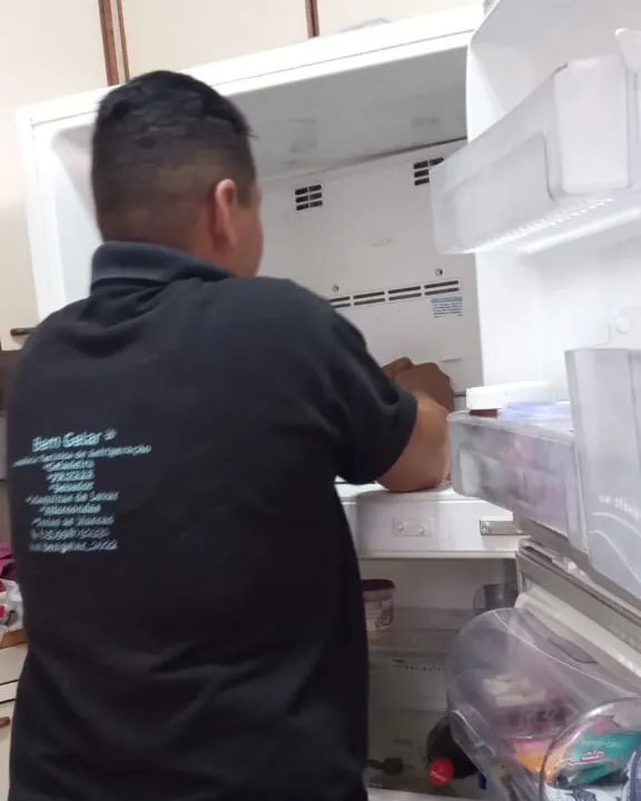 Técnica avaliando uma geladeira aberta