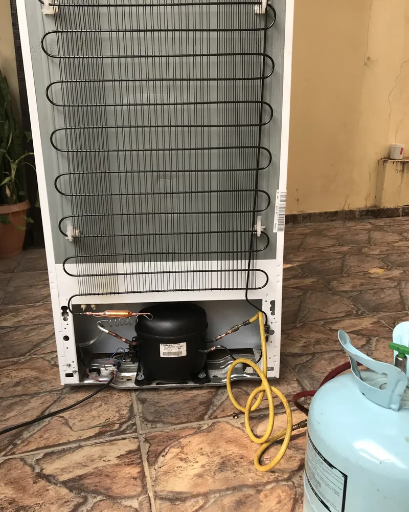 Parte de trás de uma geladeira com o compressor